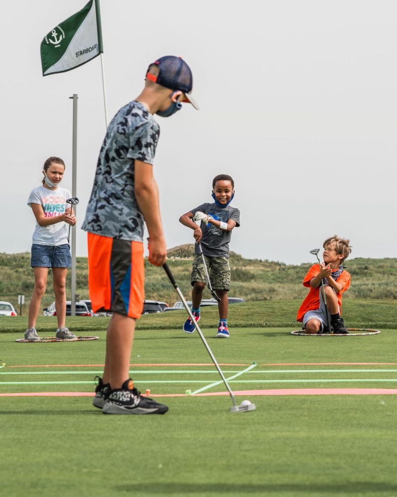 junior golfer putting at first tee program